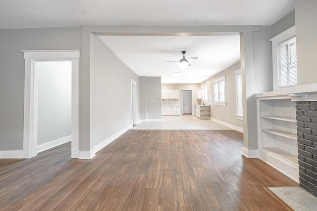 unfurnished living room with wood-type flooring, plenty of natural light, and ceiling fan