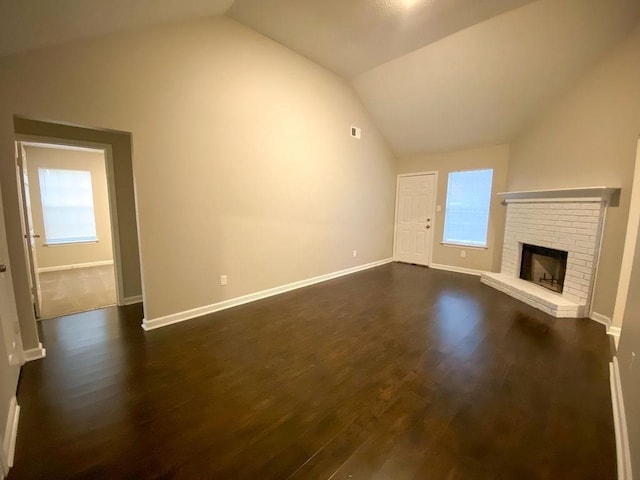 unfurnished living room featuring dark hardwood / wood-style floors, vaulted ceiling, and a brick fireplace