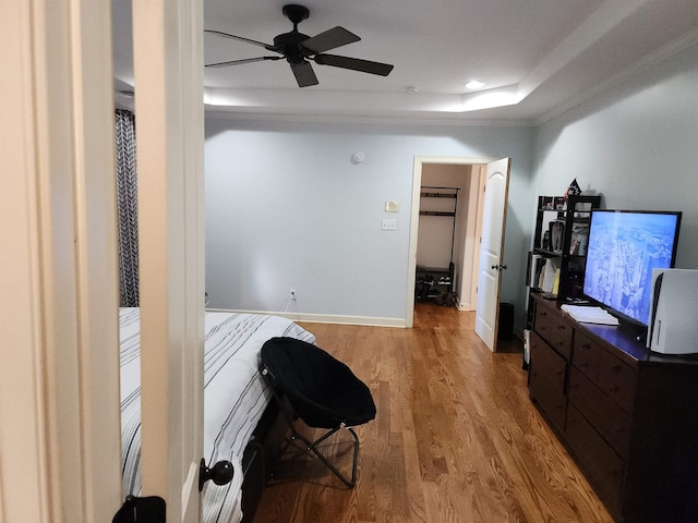 office space featuring hardwood / wood-style floors, ceiling fan, and a tray ceiling