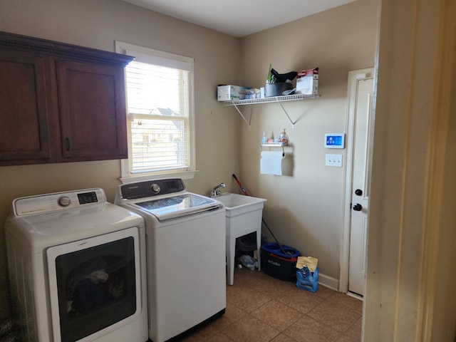 laundry area featuring cabinets, washer and dryer, and light tile patterned flooring