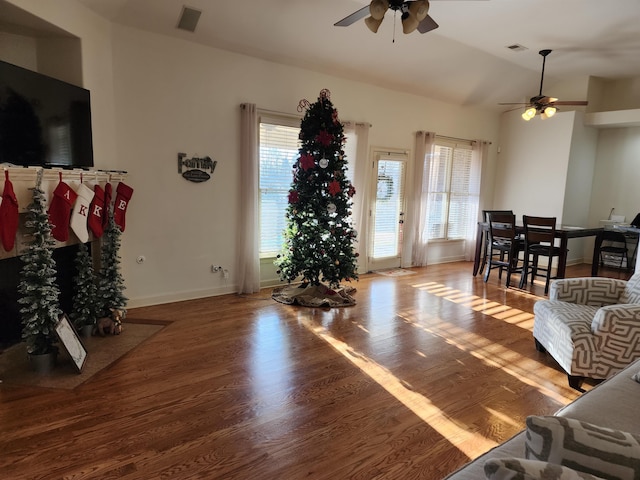 living room with hardwood / wood-style floors, vaulted ceiling, and ceiling fan