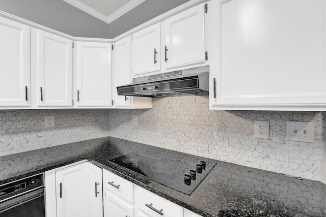 kitchen featuring black electric stovetop, crown molding, exhaust hood, dark stone countertops, and white cabinets