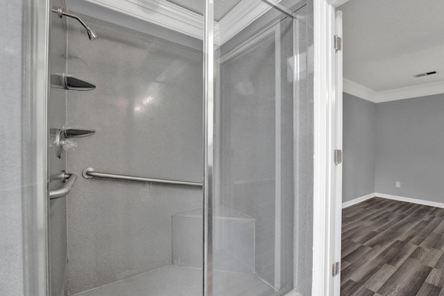 bathroom with a shower, wood-type flooring, and ornamental molding