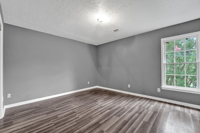 unfurnished room with a textured ceiling and dark hardwood / wood-style floors