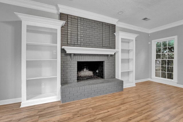 unfurnished living room with a textured ceiling, hardwood / wood-style flooring, a brick fireplace, and crown molding