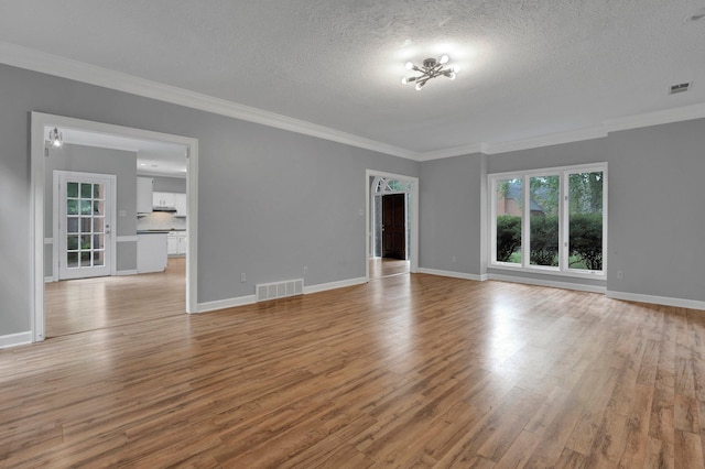 unfurnished living room with a textured ceiling, light hardwood / wood-style flooring, ornamental molding, and a notable chandelier