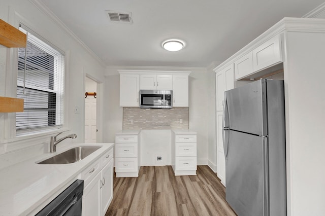 kitchen featuring white cabinetry, ornamental molding, and appliances with stainless steel finishes