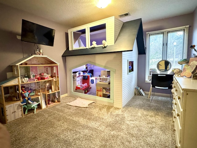 playroom with carpet floors and a textured ceiling