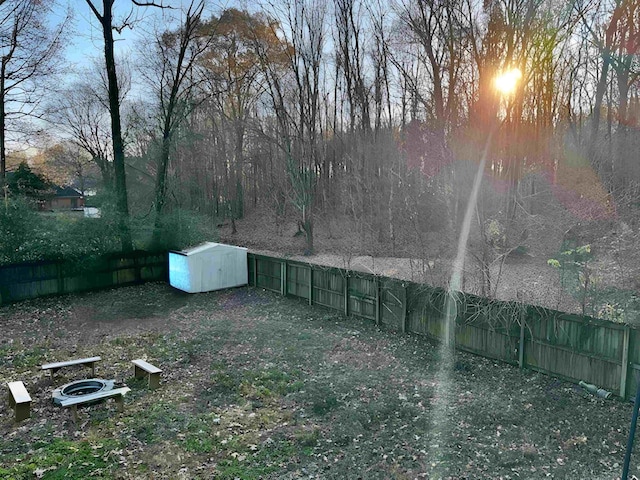 yard at dusk featuring a storage shed