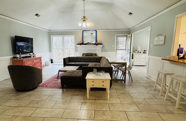 tiled living room with plenty of natural light, lofted ceiling, and ornamental molding