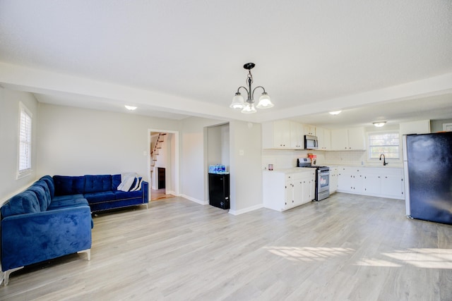 living room featuring light wood-type flooring and an inviting chandelier