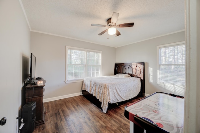 bedroom with a textured ceiling, ceiling fan, ornamental molding, and dark wood-type flooring