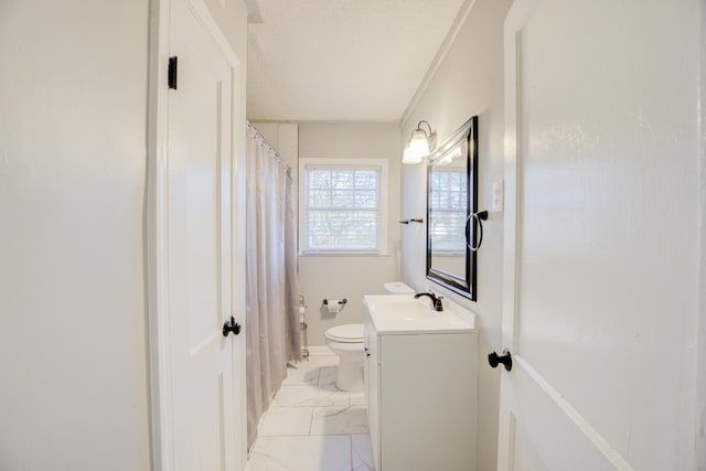 bathroom featuring a textured ceiling, vanity, and toilet