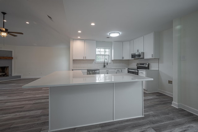 kitchen featuring white cabinetry, a center island, sink, dark hardwood / wood-style floors, and appliances with stainless steel finishes