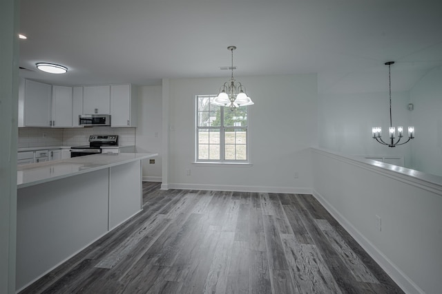 kitchen with backsplash, dark wood-type flooring, white cabinets, decorative light fixtures, and stainless steel appliances