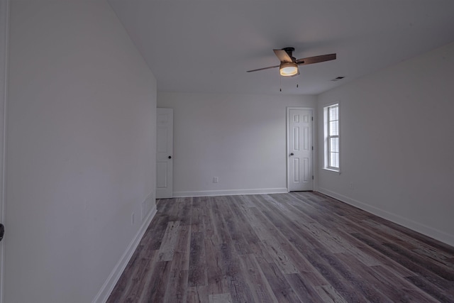 spare room with dark hardwood / wood-style floors and ceiling fan