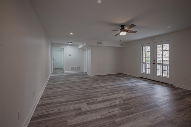 empty room featuring ceiling fan, french doors, and dark wood-type flooring