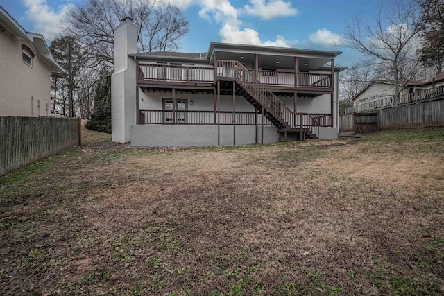 back of house featuring a yard and a wooden deck