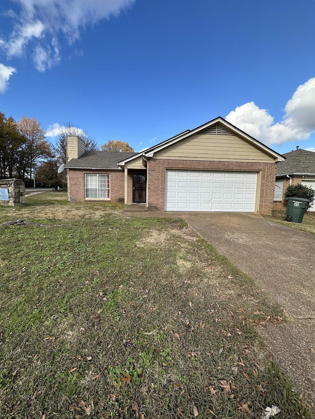 single story home featuring a garage and a front lawn