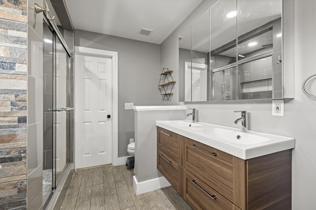 bathroom featuring vanity, an enclosed shower, and toilet