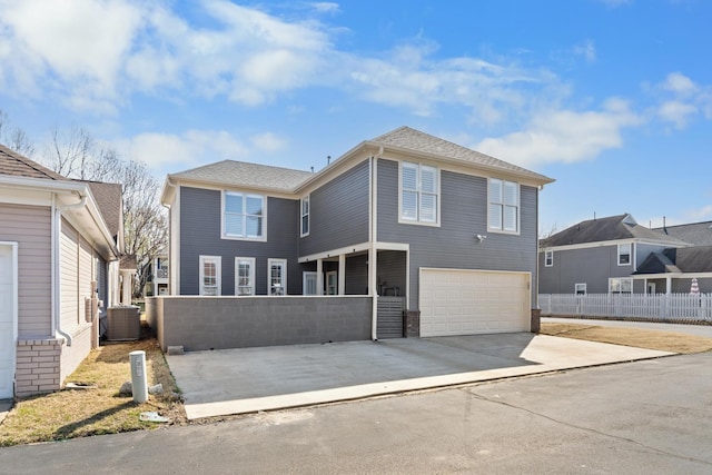 view of front of home with a garage and central air condition unit