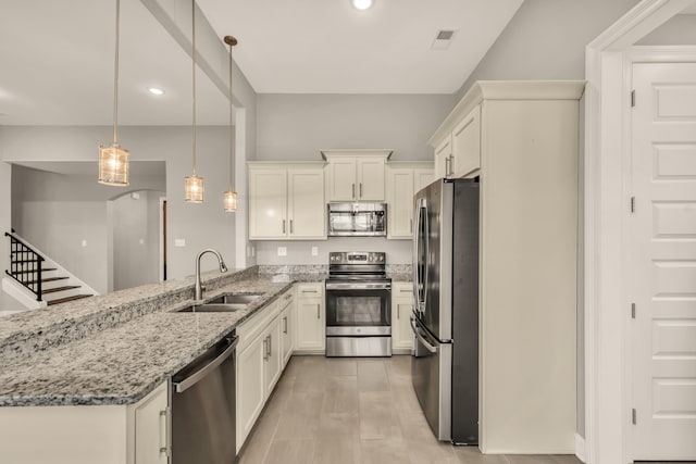 kitchen featuring white cabinets, pendant lighting, stainless steel appliances, and sink