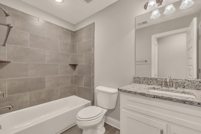 full bathroom featuring hardwood / wood-style floors, vanity, toilet, and tiled shower / bath