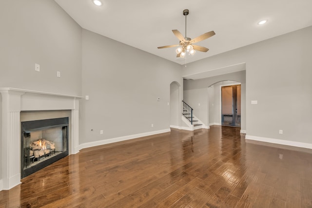 unfurnished living room with ceiling fan and dark hardwood / wood-style flooring