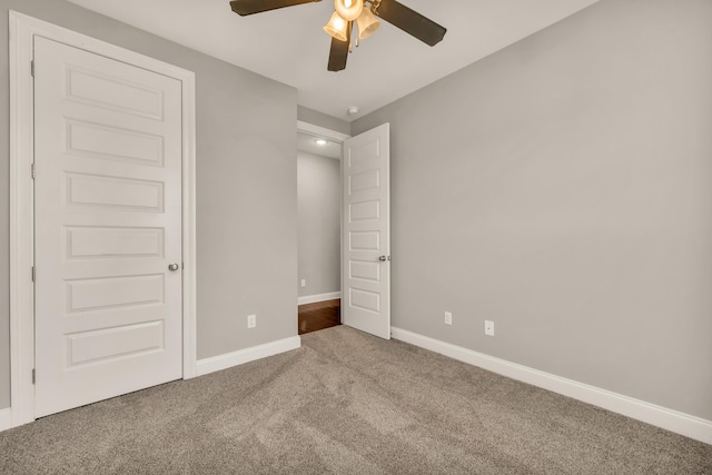 unfurnished bedroom featuring carpet, a closet, and ceiling fan