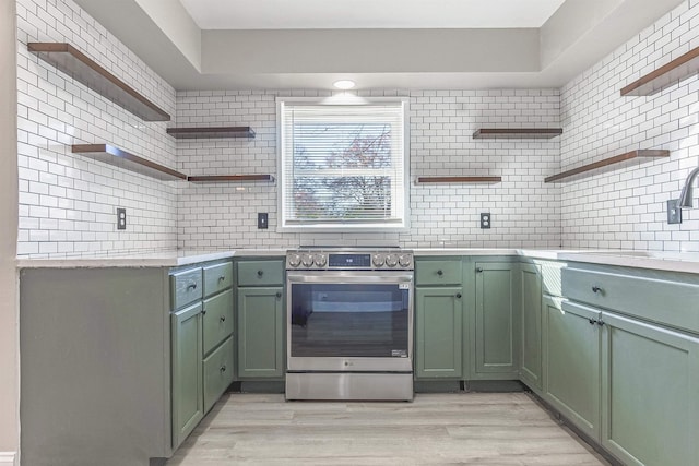 kitchen featuring light wood-type flooring, stainless steel electric range oven, tasteful backsplash, and green cabinetry