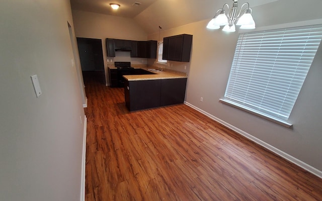 kitchen featuring dark hardwood / wood-style flooring, sink, vaulted ceiling, and a notable chandelier