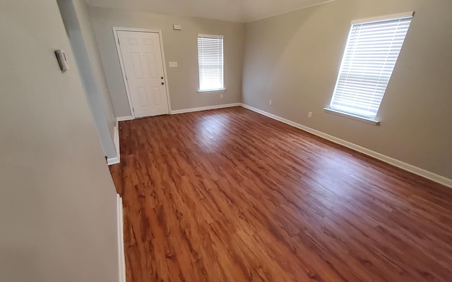 spare room featuring dark hardwood / wood-style floors and plenty of natural light