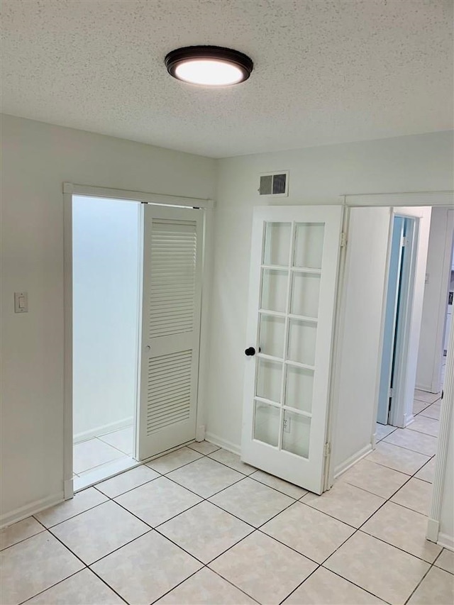 empty room featuring light tile patterned floors and a textured ceiling