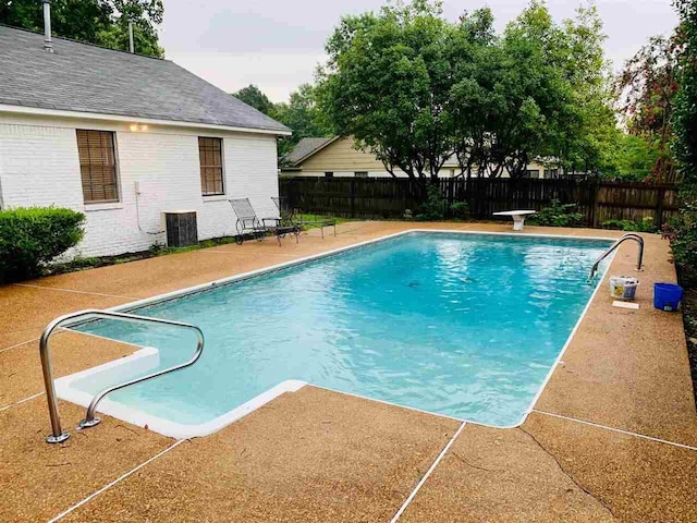 view of swimming pool with cooling unit and a patio