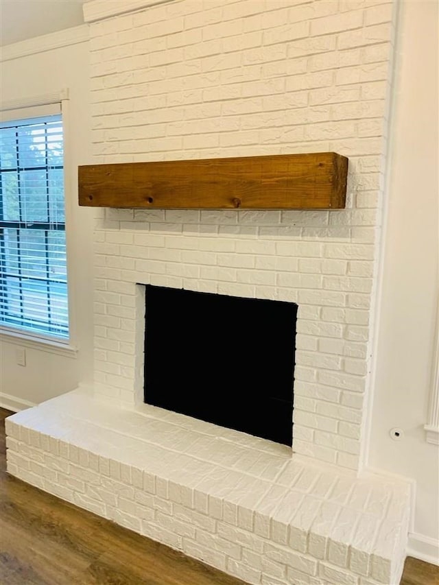 interior details featuring hardwood / wood-style floors, ornamental molding, and a fireplace