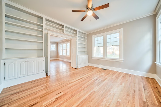 empty room with light wood-type flooring, built in features, ceiling fan, and ornamental molding