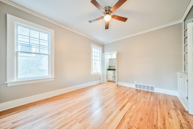 empty room featuring ceiling fan, light hardwood / wood-style flooring, and ornamental molding