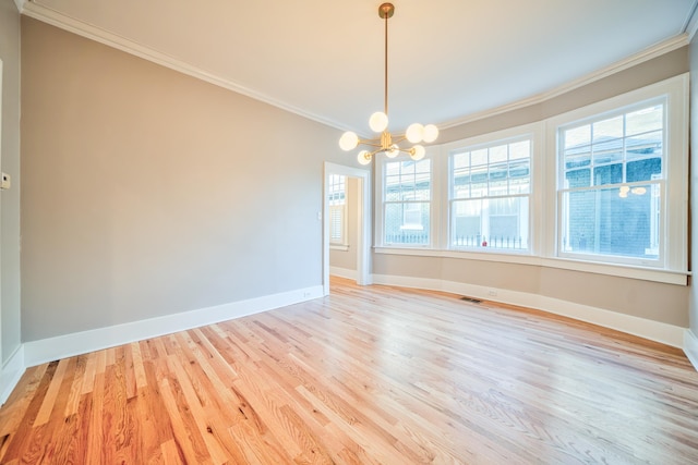 spare room with light wood-type flooring, an inviting chandelier, and crown molding