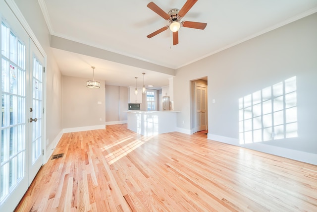 unfurnished living room featuring crown molding, french doors, light hardwood / wood-style floors, and ceiling fan with notable chandelier