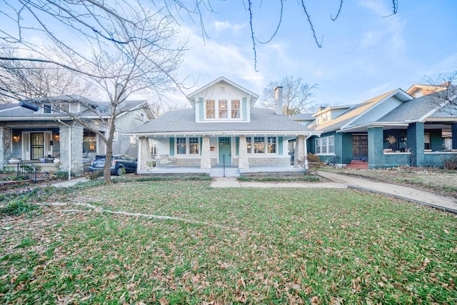 view of front of property featuring covered porch and a front lawn