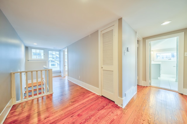 corridor with light hardwood / wood-style floors