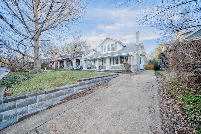 view of front of home with covered porch and a front yard