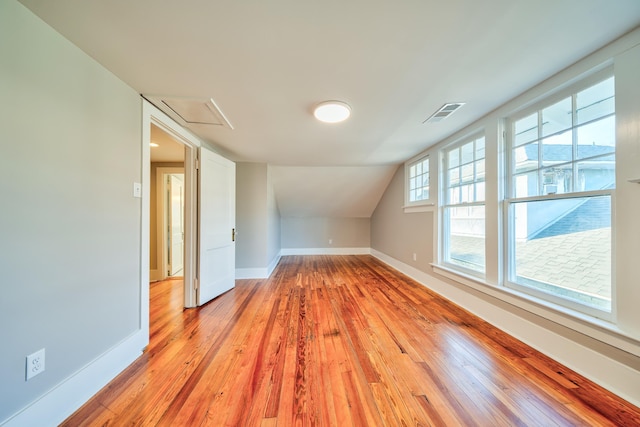 additional living space featuring light hardwood / wood-style flooring and lofted ceiling