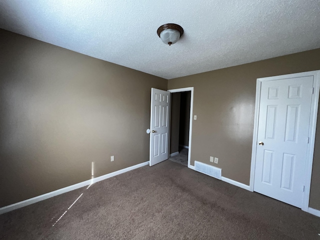 unfurnished bedroom featuring carpet floors and a textured ceiling