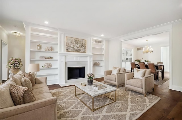 living room featuring a chandelier, built in shelves, crown molding, and dark wood-type flooring