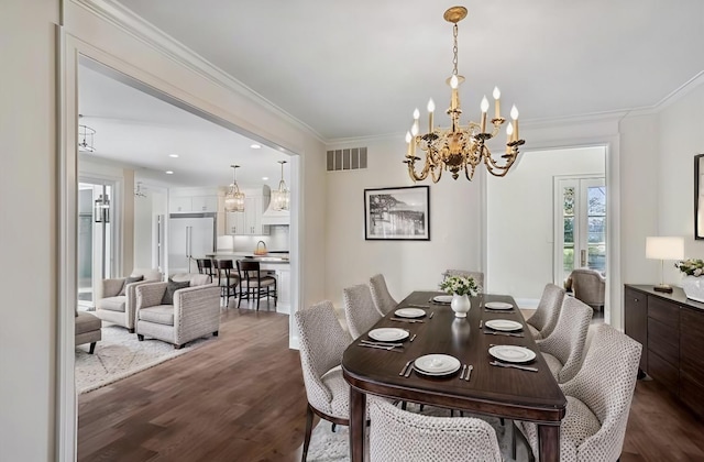 dining area with dark hardwood / wood-style flooring, ornamental molding, and a notable chandelier