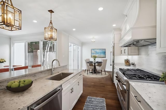 kitchen with white cabinetry, sink, light stone counters, custom exhaust hood, and appliances with stainless steel finishes