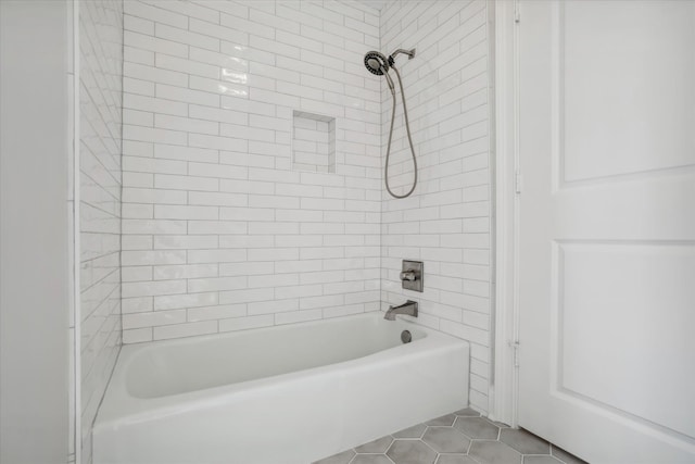 bathroom featuring tile patterned flooring and tiled shower / bath