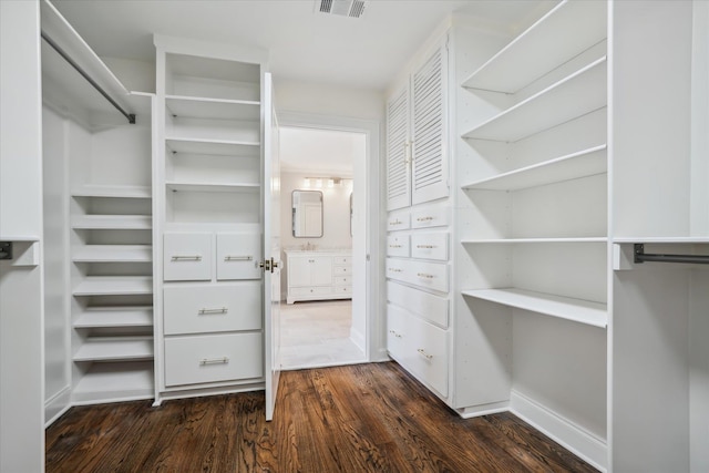 walk in closet with dark wood-type flooring