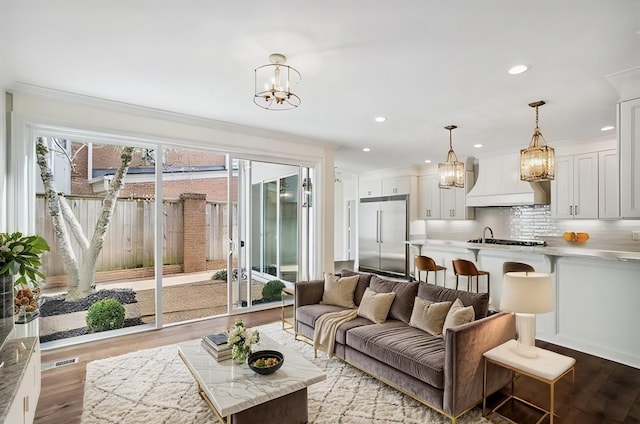 living room with ornamental molding, light hardwood / wood-style flooring, and a notable chandelier